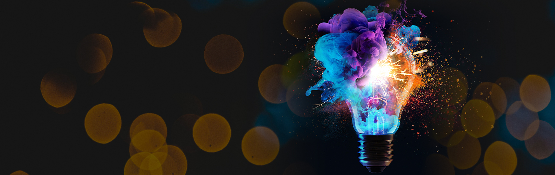A vibrant, creative light bulb explodes with colorful swirls of blue, purple, and orange against a dark background with soft, glowing bokeh circles.